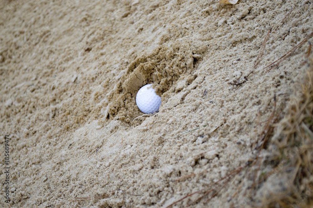 Golf ball buried in sand trap Golf ball buried in sand trap