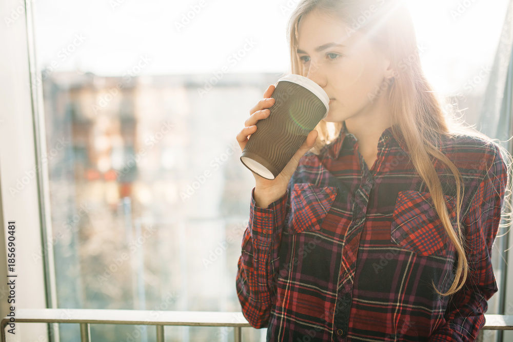 young beautiful girl drinking coffee, a woman in an office building, the bright sun, the stylish modern girl young beautiful girl drinking coffee, a woman in an office building, the bright sun, the stylish modern girl