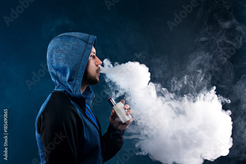 vaping man holding a mod. A cloud of vapor.