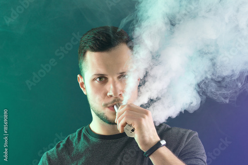 vaping man holding a mod. A cloud of vapor.