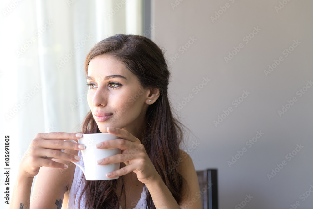Woman having coffee and smile. Beautiful white woman having her morning coffee and smile looking very happy. Woman having coffee and smile. Beautiful white woman having her morning coffee and smile looking very happy.