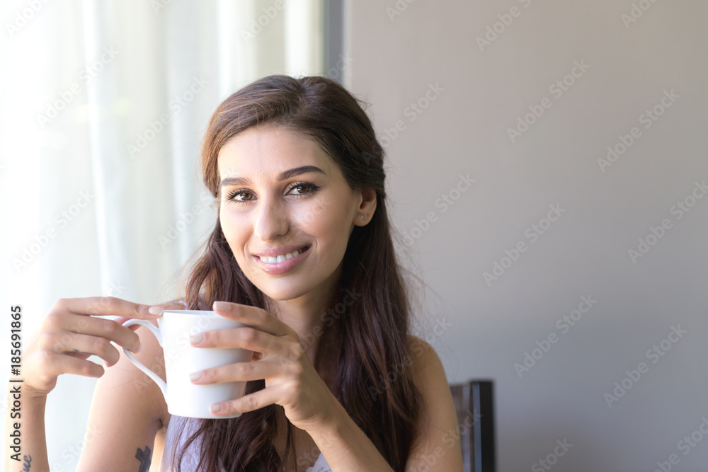 Woman having coffee and smile. Beautiful white woman having her morning coffee and smile looking very happy. Woman having coffee and smile. Beautiful white woman having her morning coffee and smile looking very happy.