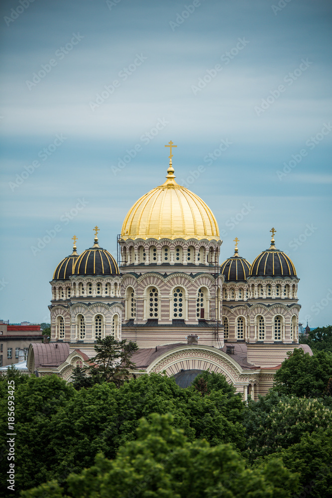 Orthodox Cathedral golden dome above Riga city trees.