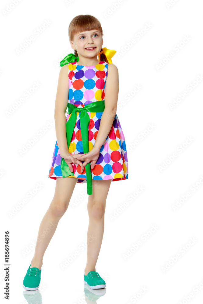 A little girl in a dress with a pattern from multi-colored circl A little girl in a dress with a pattern from multi-colored circl