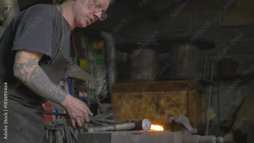 Master blacksmith working on his art, sparks fly Master blacksmith working on his art, sparks fly