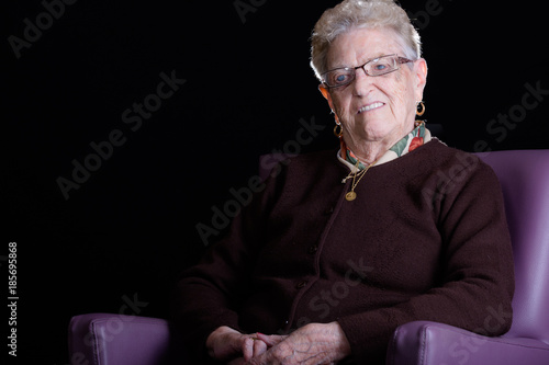 Portrait of a happy senior woman smiling at the camera. Over black background.
