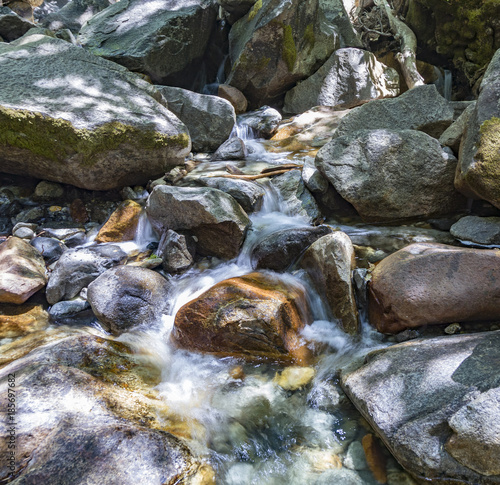 colorful stones in the clear cold water of a creek