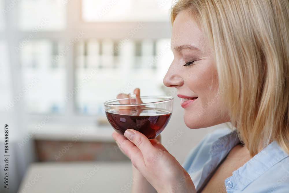 So flavoring. Close up profile of glad woman smelling black tea. Her eyes are closed. Copy space in left side So flavoring. Close up profile of glad woman smelling black tea. Her eyes are closed. Copy space in left side