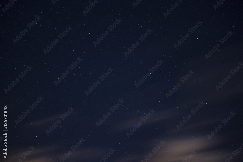 Fototapeta premium Stars in the night sky background with clouds on a long exposure