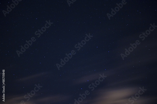 Stars in the night sky background with clouds on a long exposure
