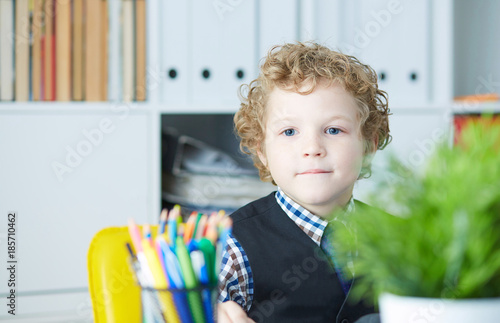 Funny child looks like a boss on a subordinate. Little boss in office. photo