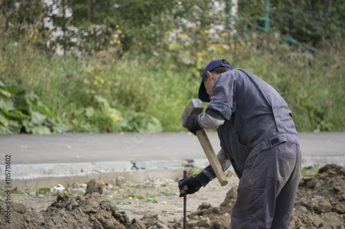 Tough worker with iron chain and sledgehammer