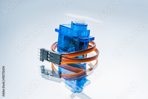 microelectronic servomotor on white background. component for control of robots and radio-controlled toys photo