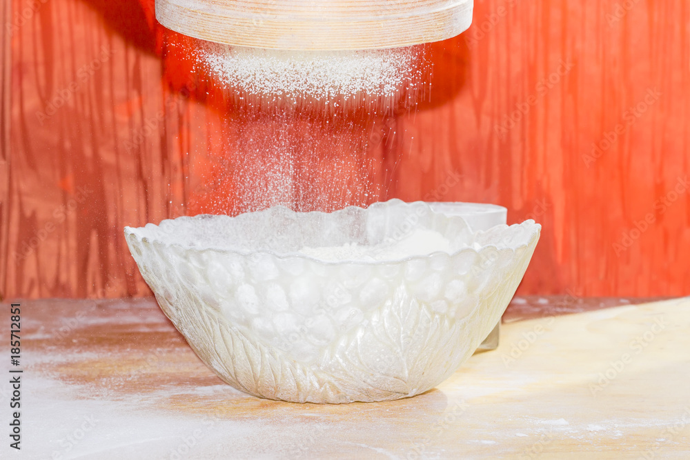 Flour during sifting into a glass bowl Flour during sifting into a glass bowl