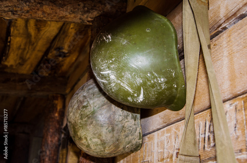 Old military green helmet infantry of WWII (world war 2). Military helmet is an army symbol of defense. Military helmets hanging on a wooden wall. A genuine vintage military classic helmet.