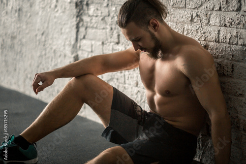 Fotografie Young muscular man resting after gym workout.