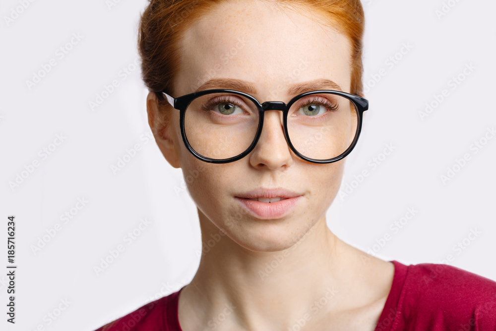 Close up portrait of attractive young redhead woman smiling with glasses Close up portrait of attractive young redhead woman smiling with glasses