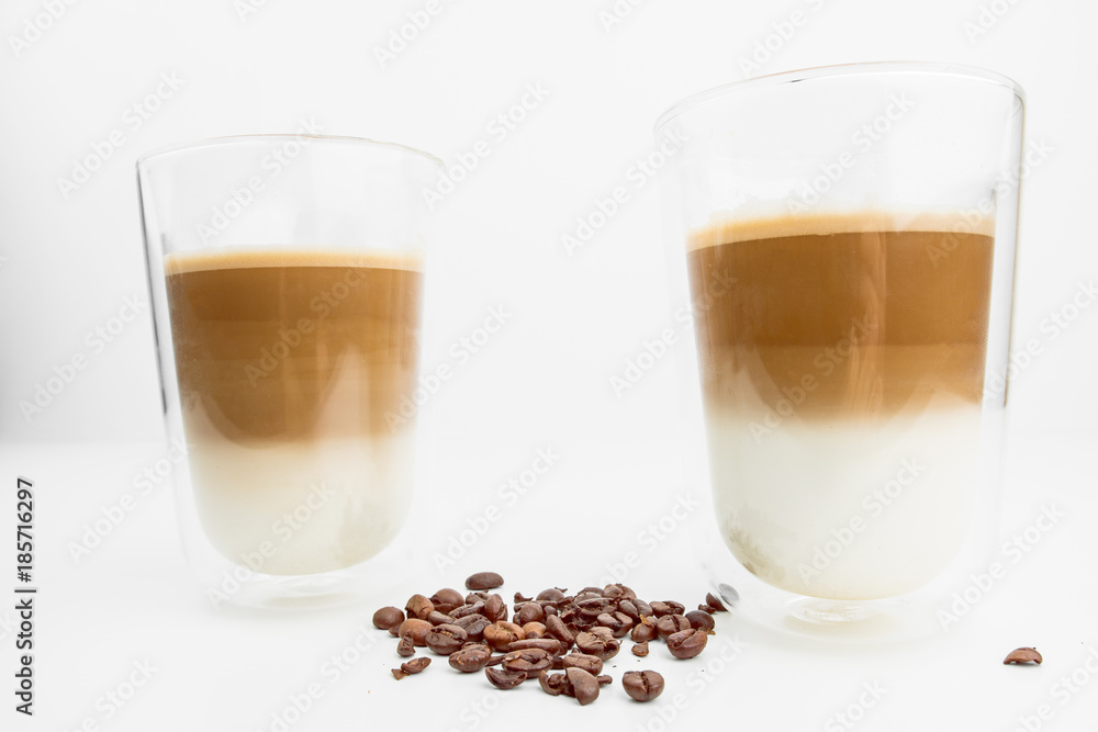 Two Hot Coffee Drinks With Milk With Coffee Beans On White Background Two Hot Coffee Drinks With Milk With Coffee Beans On White Background
