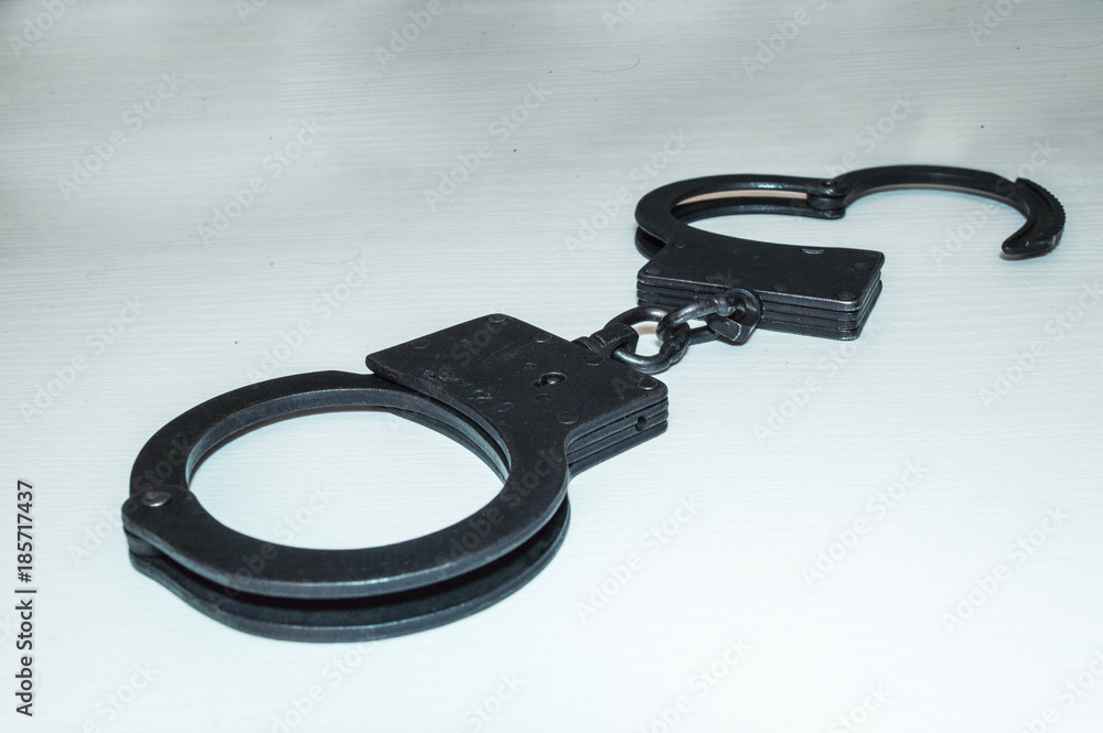 Metal police handcuffs on a white background. You are under arrest Metal police handcuffs on a white background. You are under arrest