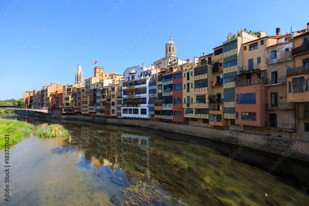 Colorful yellow and orange houses in water river Onyar, Girona, Spain