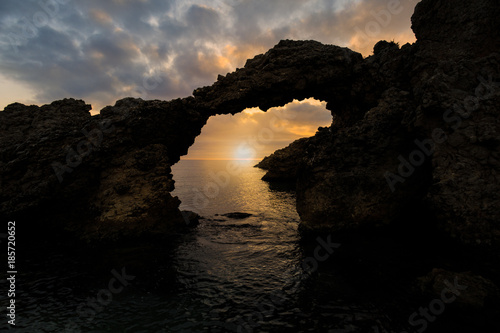Sunrise over the natural arch of the beach of Portitxol in L'Escala, Costa Brava - Girona, Spain
