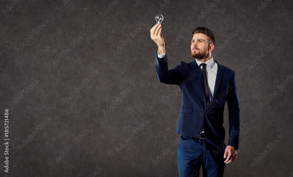 Businessman with luminous light bulb in hand on copyspase background. Businessman with luminous light bulb in hand on copyspase background.