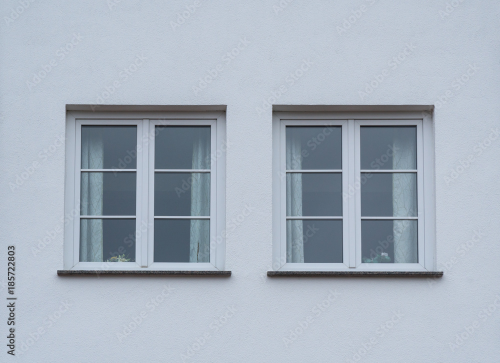 Weiße Fenster eines Hauses mit weißer Fassade Stock-Foto | Adobe Stock