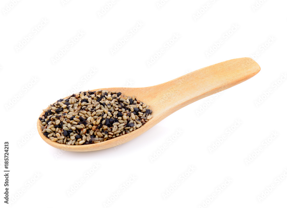 Sesame seeds in wooden spoons isolated on white background Sesame seeds in wooden spoons isolated on white background