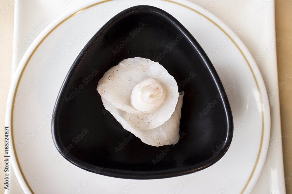 Rose flower shaped cod Sashimi Sushi over black bowl. Closeup Rose flower shaped cod Sashimi Sushi over black bowl. Closeup