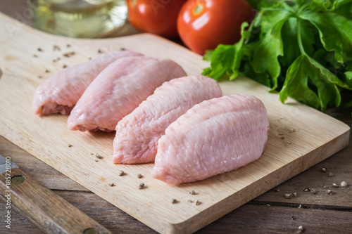 Raw chicken wings on wooden cutting board