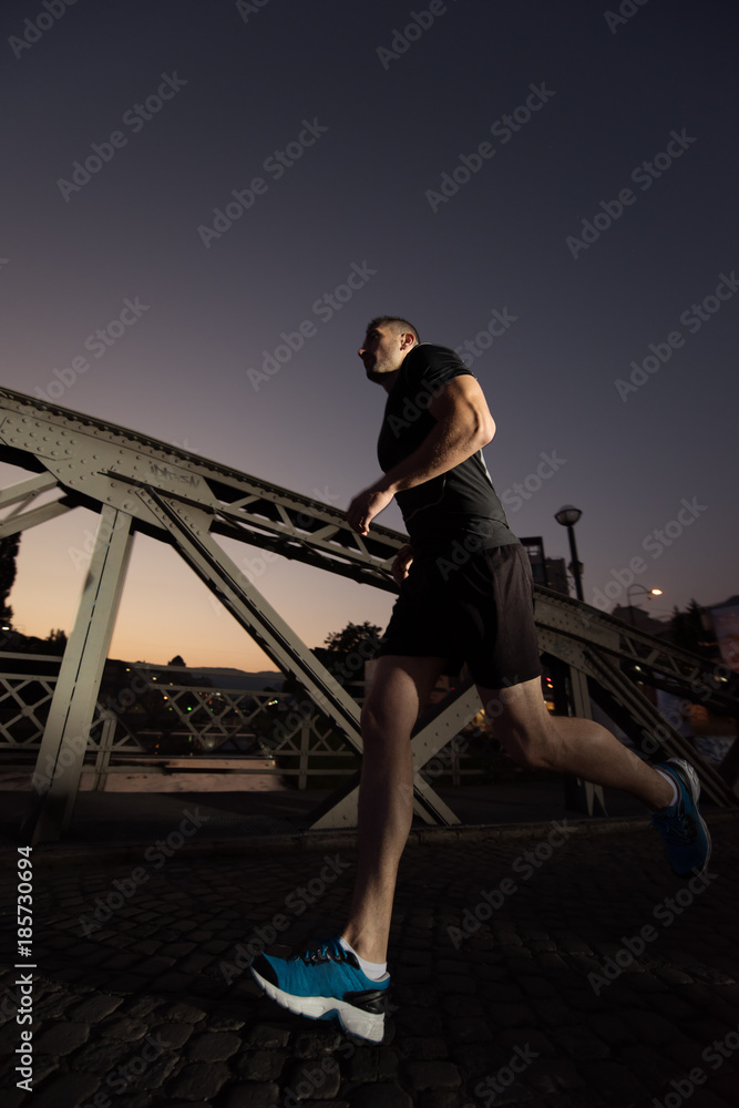 man jogging across the bridge in the city man jogging across the bridge in the city