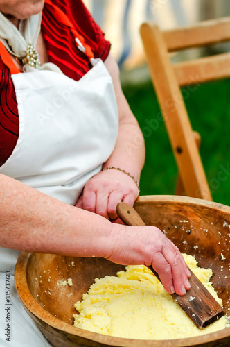 An elderly Irish lady uses a paddle to hand-make butter. photo