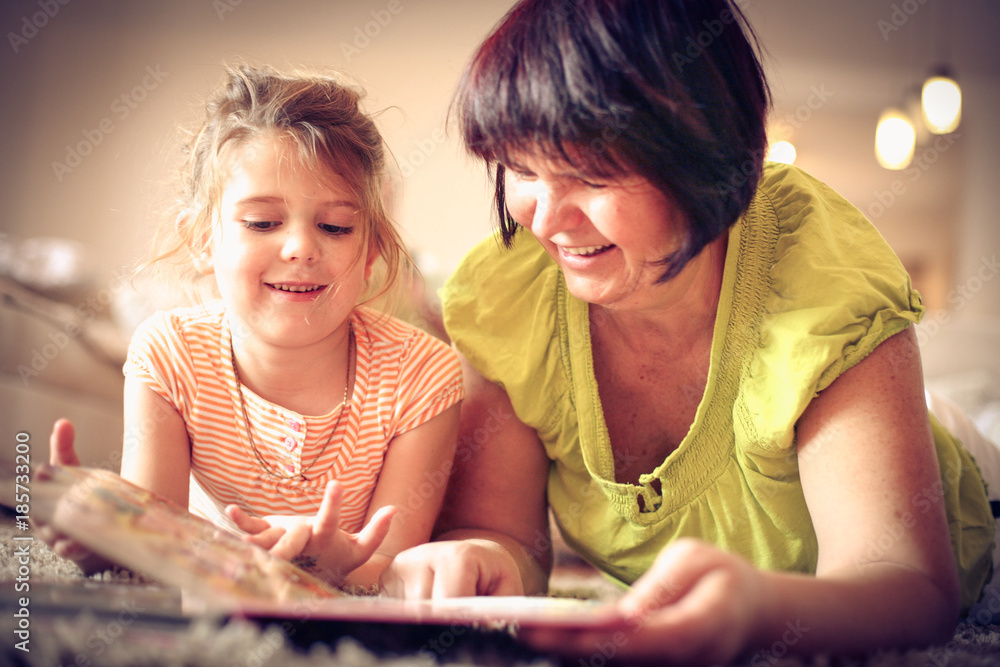 Grandmother reading a book with little girl. Close up. Grandmother reading a book with little girl. Close up.