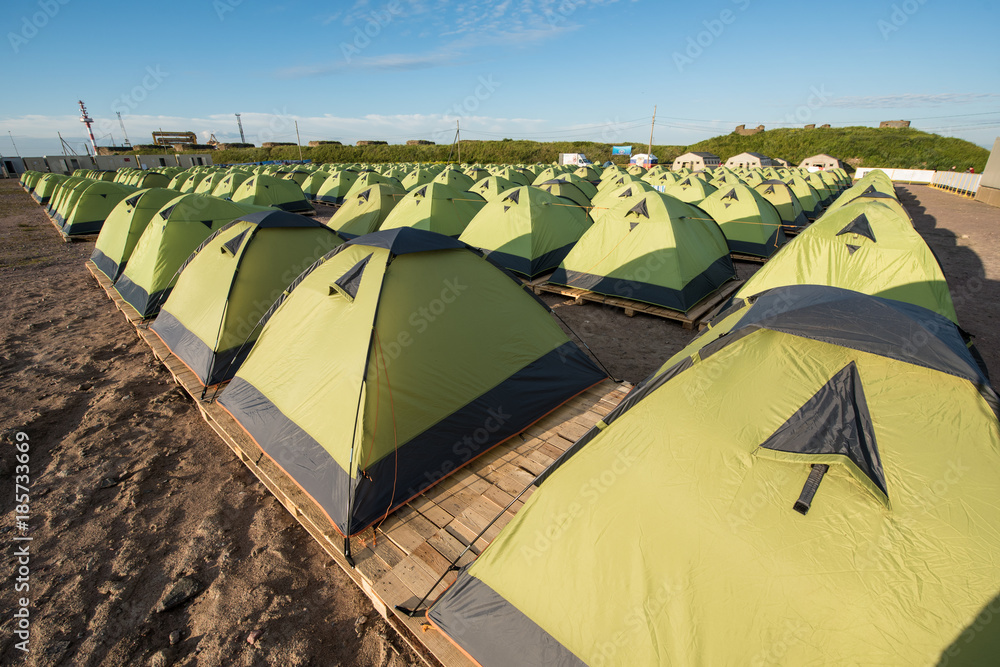 A number of green tourist double tents in line