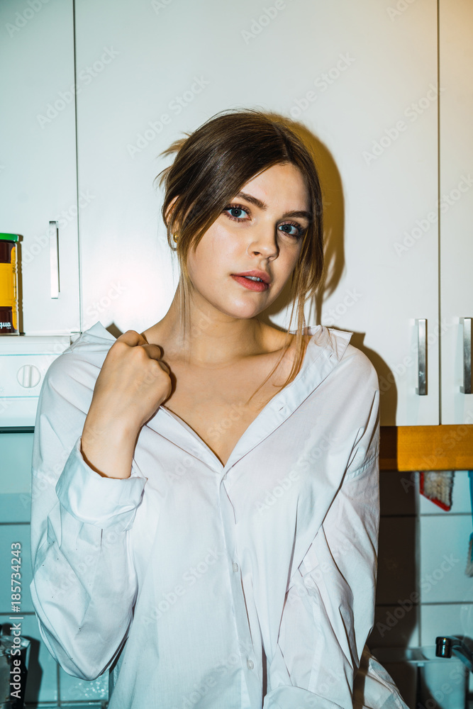 Portrait of young woman sitting in kitchen