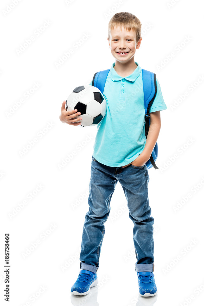 schoolboy with backpack holding a football ball isolated in full length on a white background