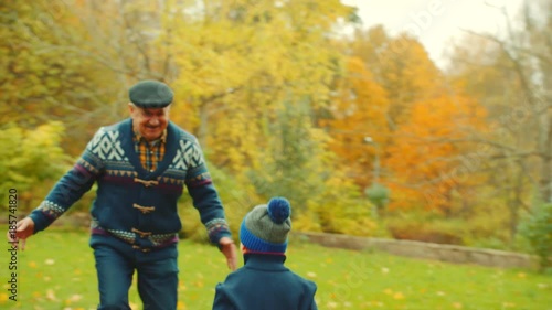 Wallpaper Mural Little boys are playing with their grandfather with fallen leaves in the autumn park Torontodigital.ca