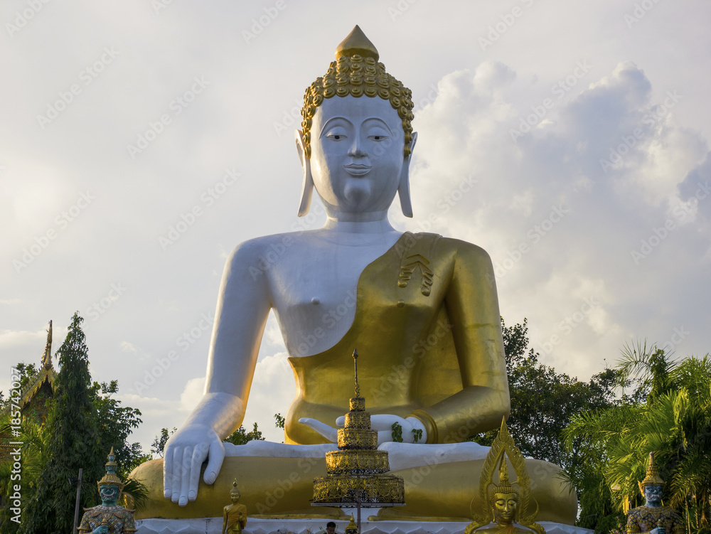 Fototapeta premium Big Buddha statue over the bright blue sky at Wat Phra That Doi Kham (Temple of the Golden Mountain) in Chiang Mai, Thailand with copy space