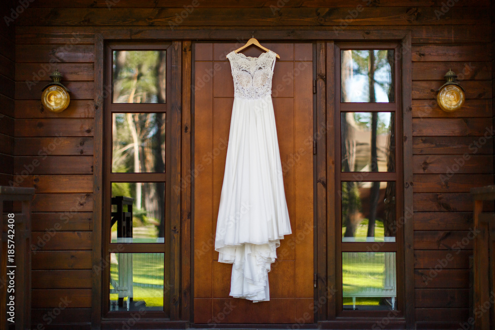Wedding dress hanging on the wooden door Wedding dress hanging on the wooden door