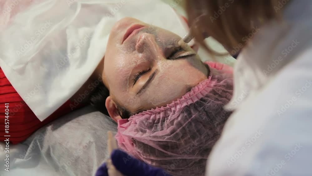 The girl during the procedure bb glow. The woman on reception at the beautician. The process of applying the mask on the face The girl during the procedure bb glow. The woman on reception at the beautician. The process of applying the mask on the face