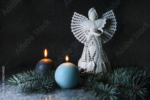 Crochet Christmas angel with candles on a dark gray background