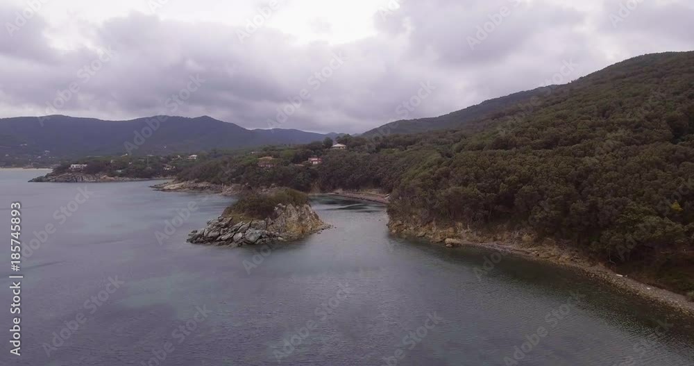 Aerial, beautiful calm sea and a tiny island near the island coast on cloudy day Aerial, beautiful calm sea and a tiny island near the island coast on cloudy day