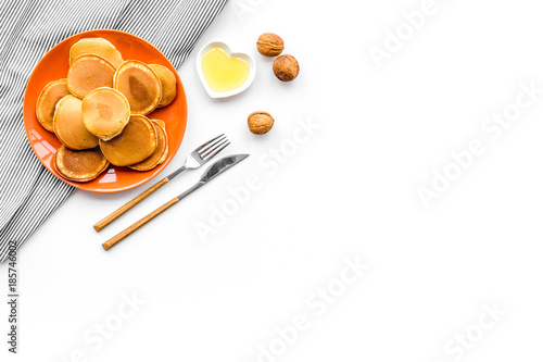 Cooking american pancakes. Ingredients, cakes, nuts and honey on white background top view copyspace
