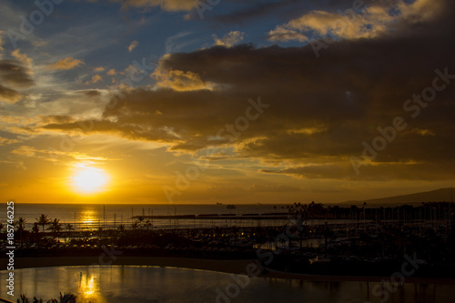 Tropical Sunset, Waikiki Beach, Honolulu, Hawaii with silhouette palm tress, sea and sand