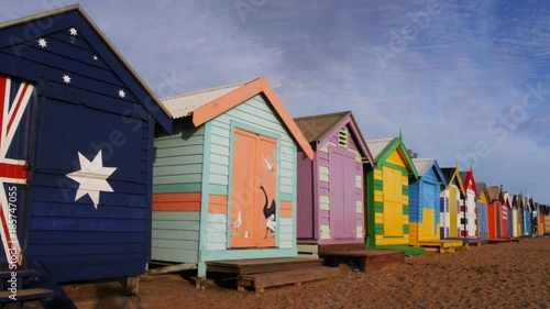 a panning shot of the uniquely decorated huts at brighton beach, melbourne photo