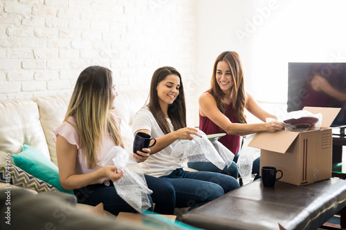 Friends unpacking boxes together