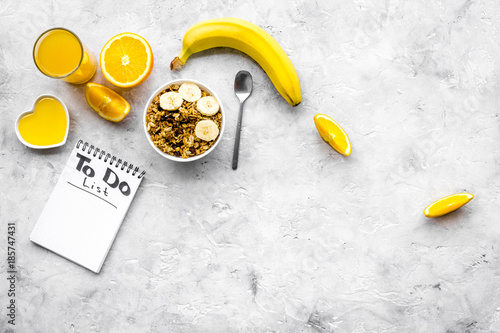 Start the day the right way. Healthy breakfast oatmeal with fruits and planning the day. Grey background top view copyspace