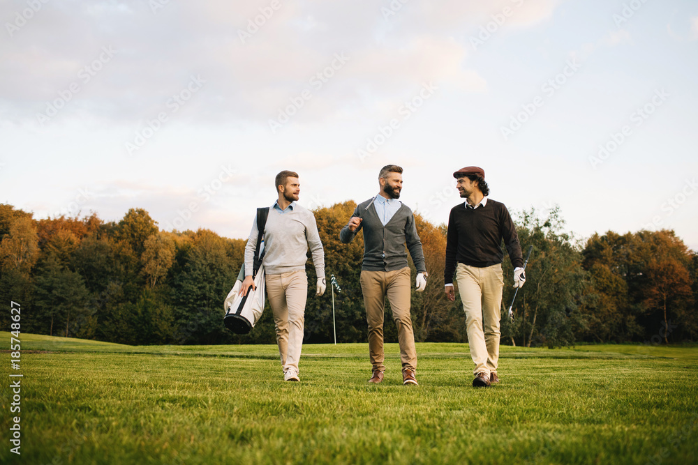 Mans playing golf on a golf course in the sun Mans playing golf on a golf course in the sun