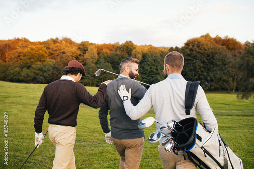 Quadro su tela Mans playing golf on a golf course in the sun