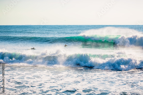 Perfect breaking blue wave and surfers © artifirsov